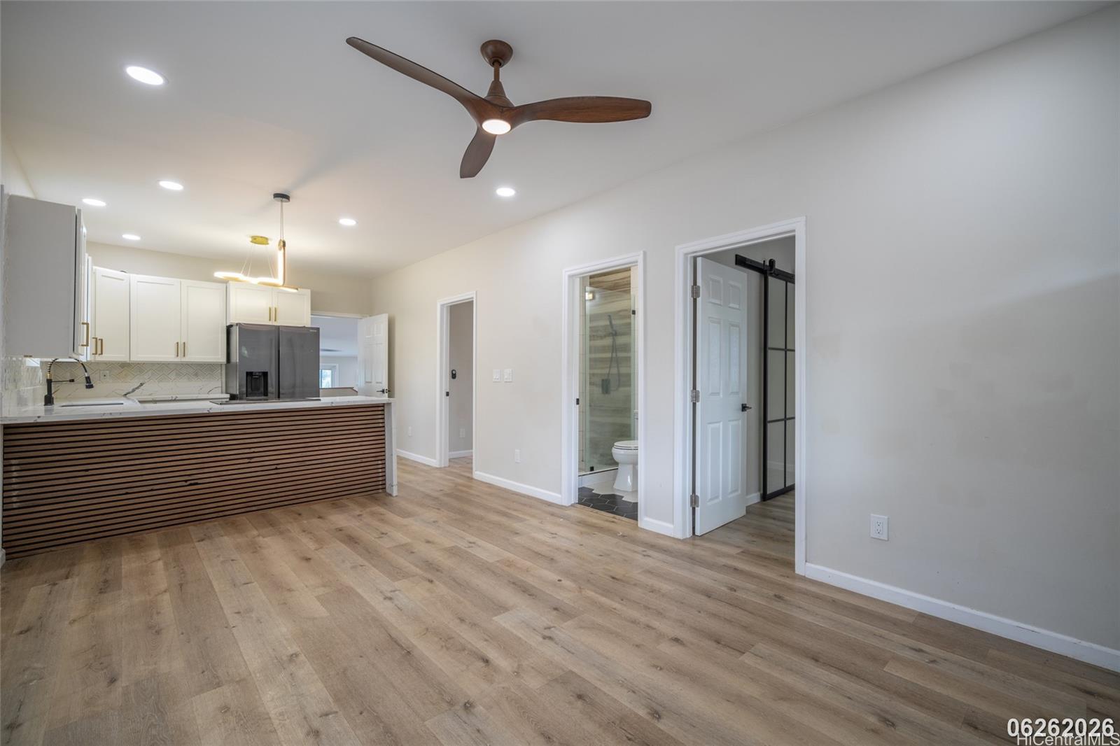 87-1409 Akowai Road Waianae, HI 96792 - Photo 8 of 25 an empty room with wooden floor and ceiling fan