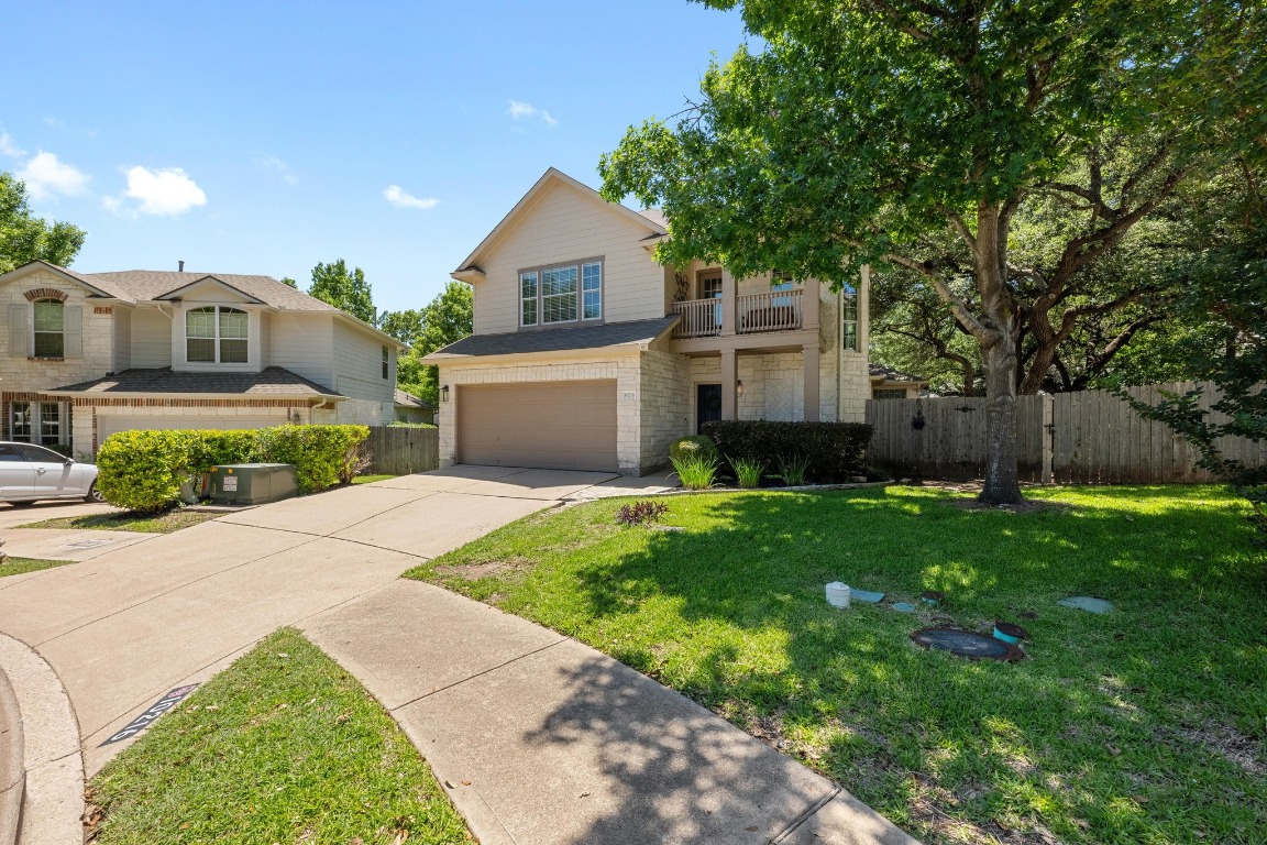 a front view of a house with a garden and trees