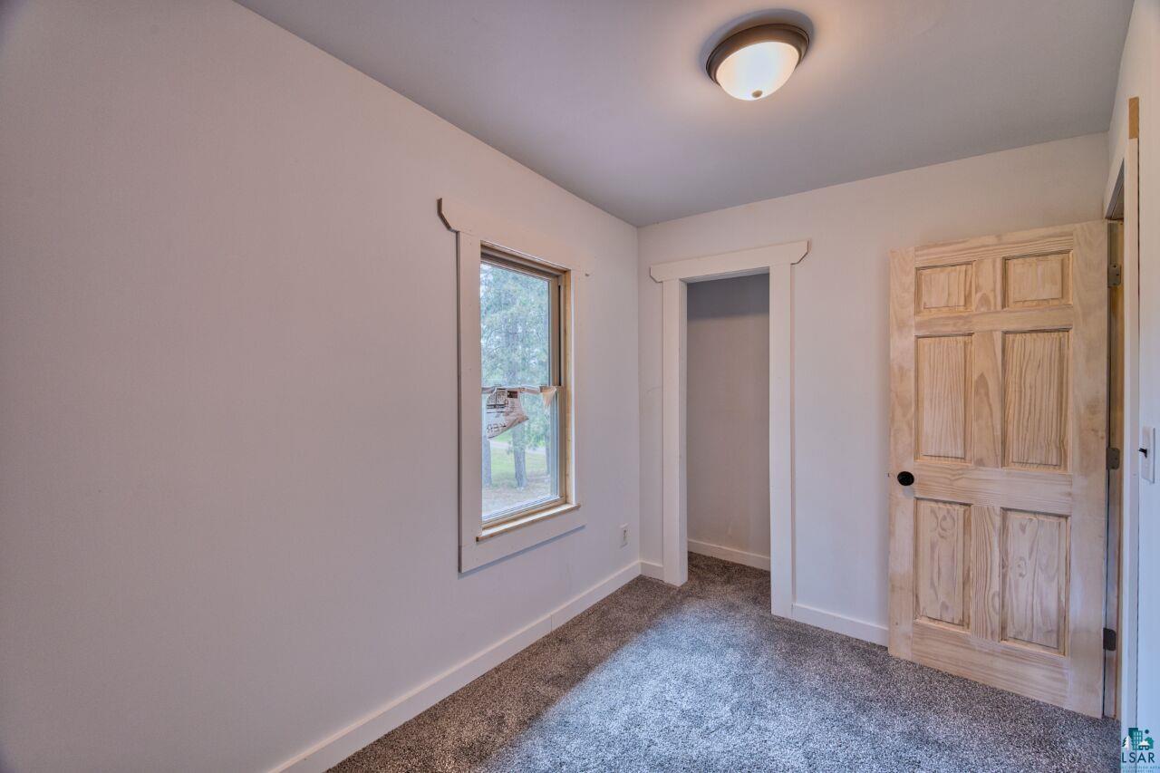 4755 Judd Road Gilbert, MN 55741 - Photo 23 of 50 Unfurnished bedroom featuring dark carpet and baseboards