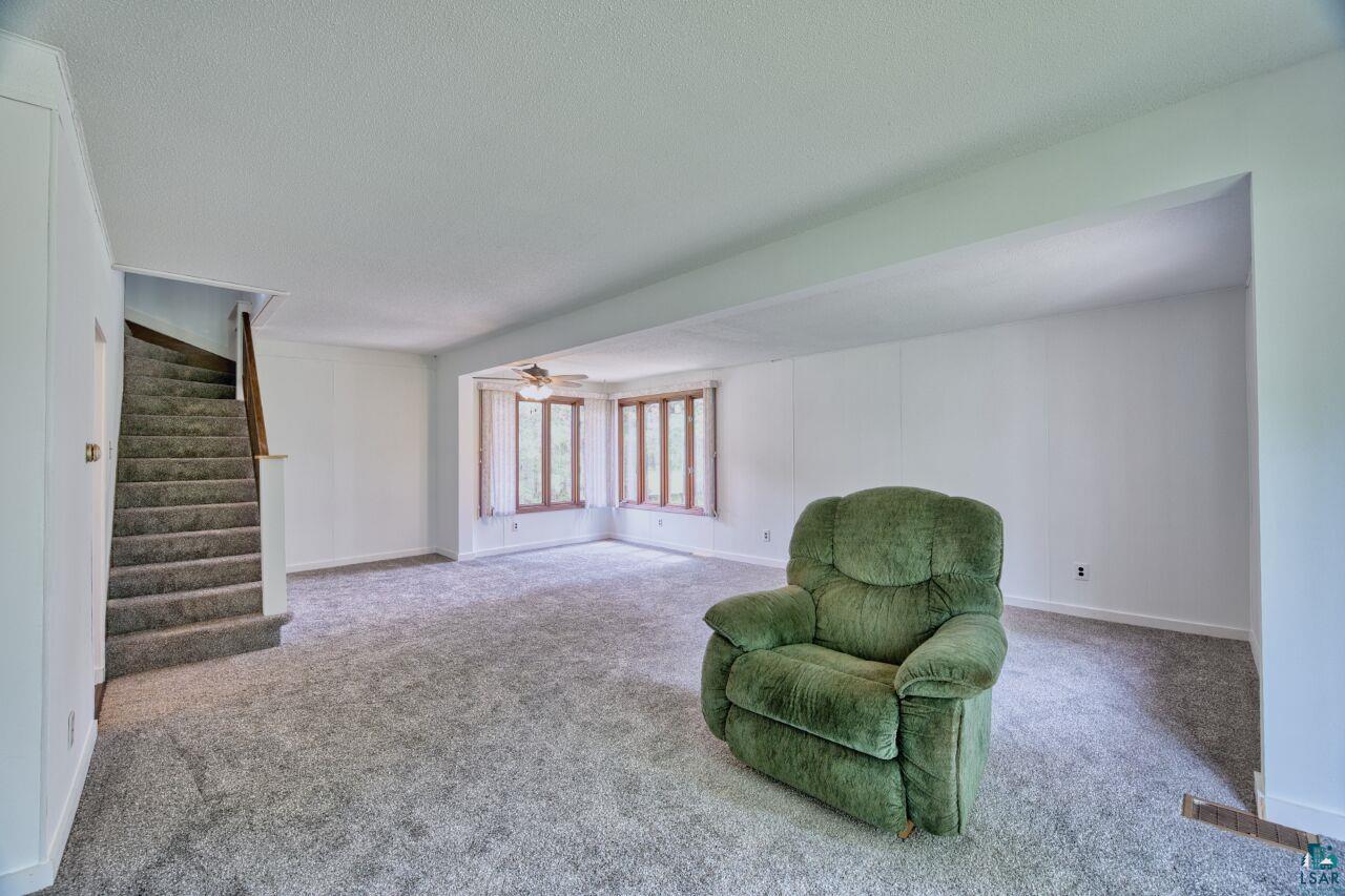 4755 Judd Road Gilbert, MN 55741 - Photo 5 of 50 Sitting room featuring carpet flooring, stairs, ceiling fan, a textured ceiling, and baseboards