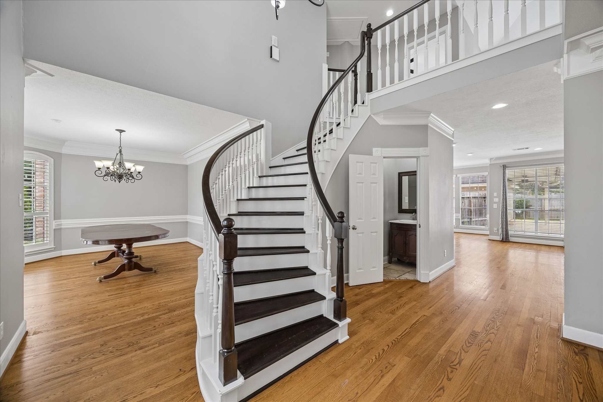 7915 Huddersfield Court Spring, TX 77379 - Photo 10 of 37 A gracious two-story entry with hardwood floors and a curved staircase opens to the formal dining room, powder bath, and spacious main living areas.