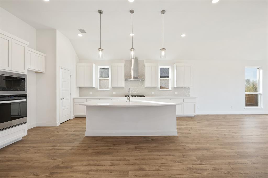 735 Oak Lavon, TX 75166 - Photo 19 of 39 a view of a kitchen with kitchen island a sink stainless steel appliances and cabinets