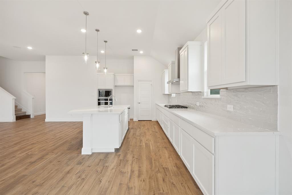 735 Oak Lavon, TX 75166 - Photo 23 of 39 a large white kitchen with wooden floor and stainless steel appliances