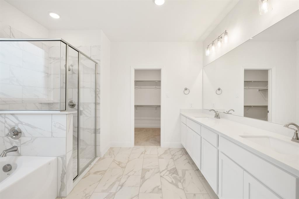 735 Oak Lavon, TX 75166 - Photo 29 of 39 a bathroom with a double vanity sink and mirror with bathtub