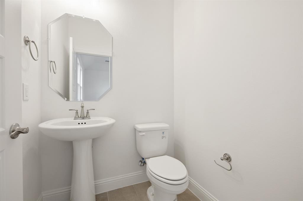 735 Oak Lavon, TX 75166 - Photo 36 of 39 a bathroom with a toilet sink and mirror