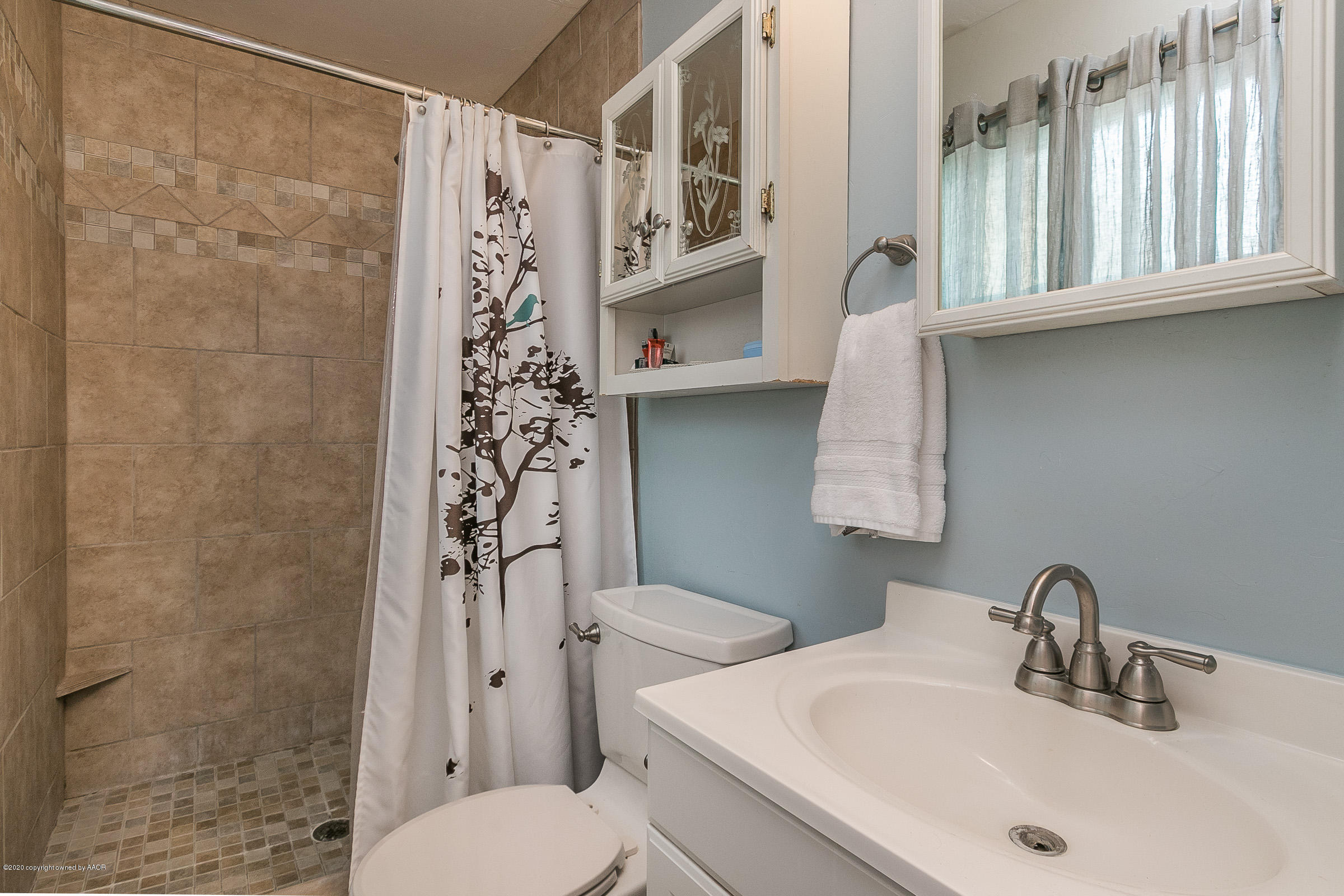 4709 South Austin Street Amarillo, TX 79110 - Photo 13 of 22 a bathroom with a sink a toilet and shower curtain