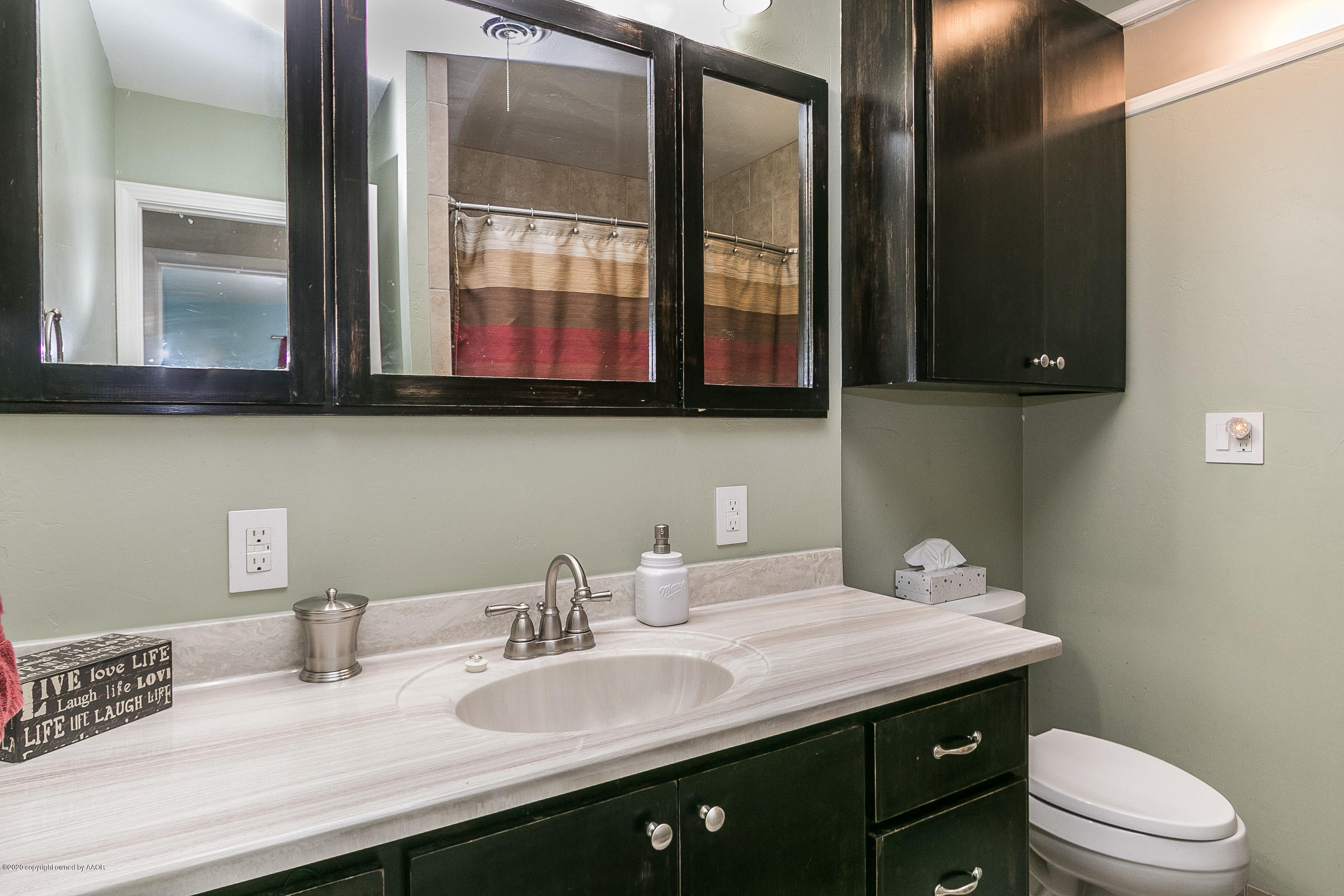 4709 South Austin Street Amarillo, TX 79110 - Photo 17 of 22 a bathroom with a sink a toilet and mirror