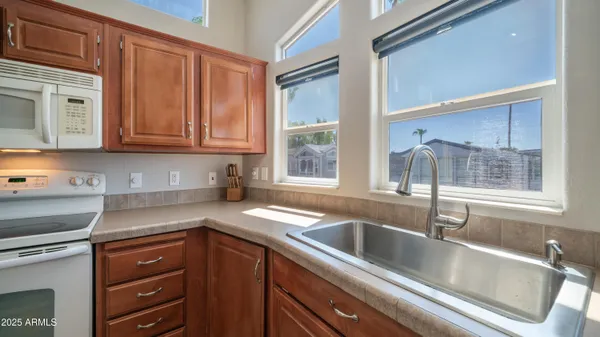 a kitchen with stainless steel appliances granite countertop a white cabinets and a stove top oven