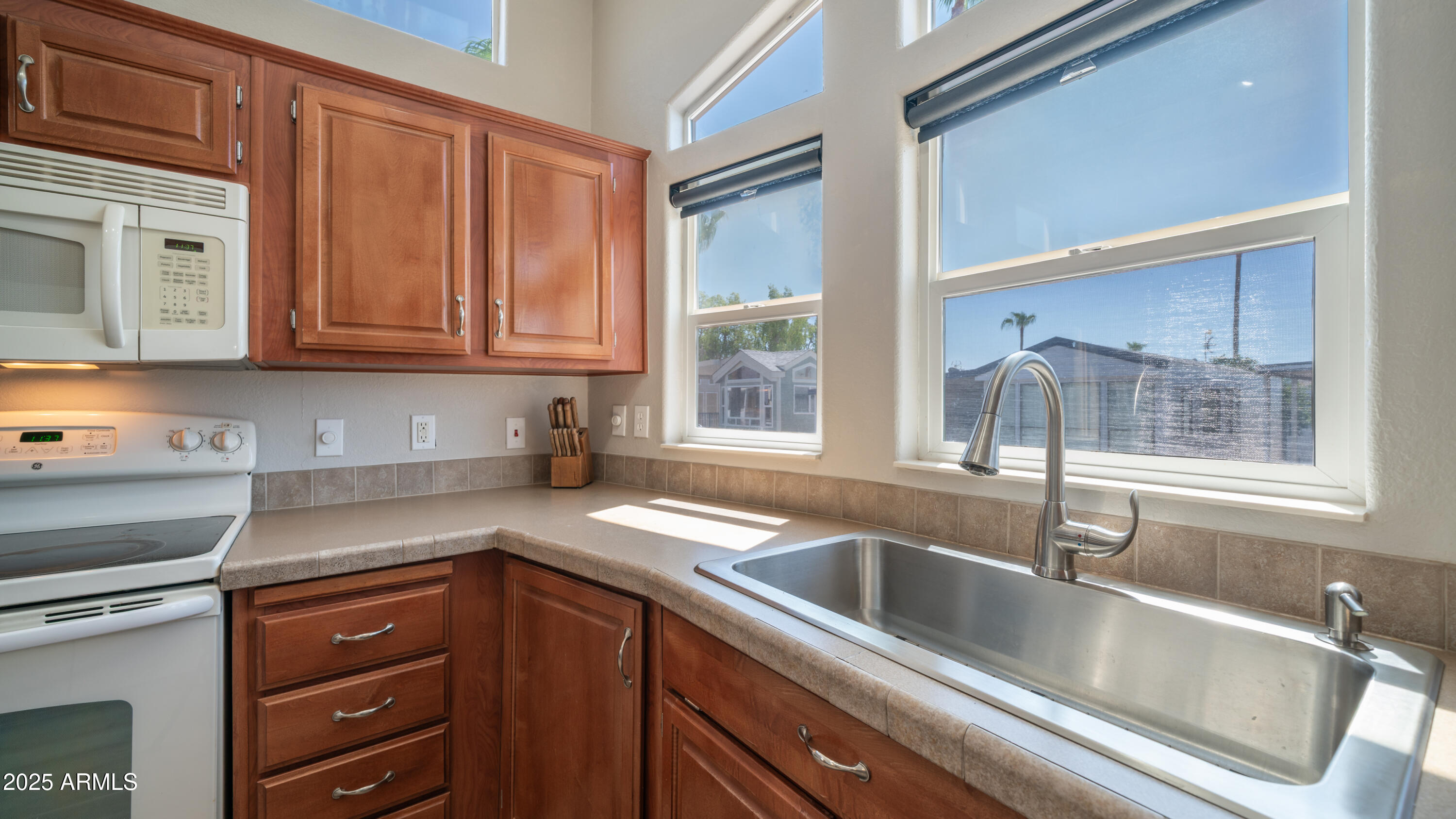 2400 East Baseline Avenue Apache Junction, AZ 85119 - Photo 16 of 64 a kitchen with granite countertop a sink stainless steel appliances and cabinets
