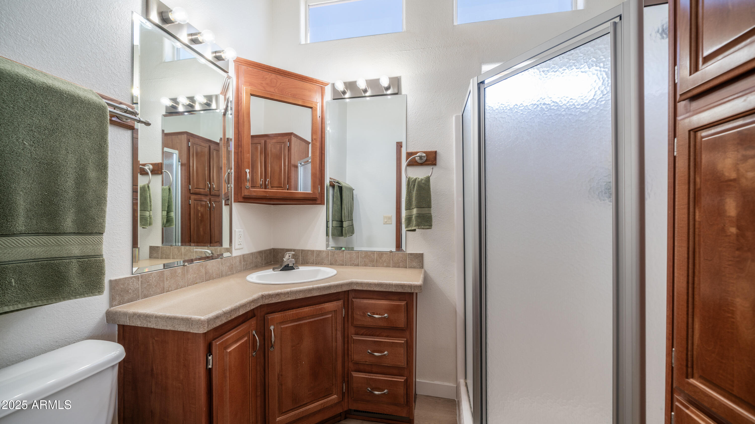 2400 East Baseline Avenue Apache Junction, AZ 85119 - Photo 20 of 64 a bathroom with a granite countertop sink a toilet a mirror and shower