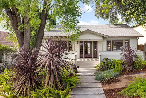 a front view of a house with a tree