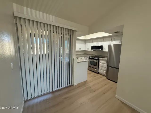 a kitchen with stainless steel appliances granite countertop a refrigerator and a stove top oven