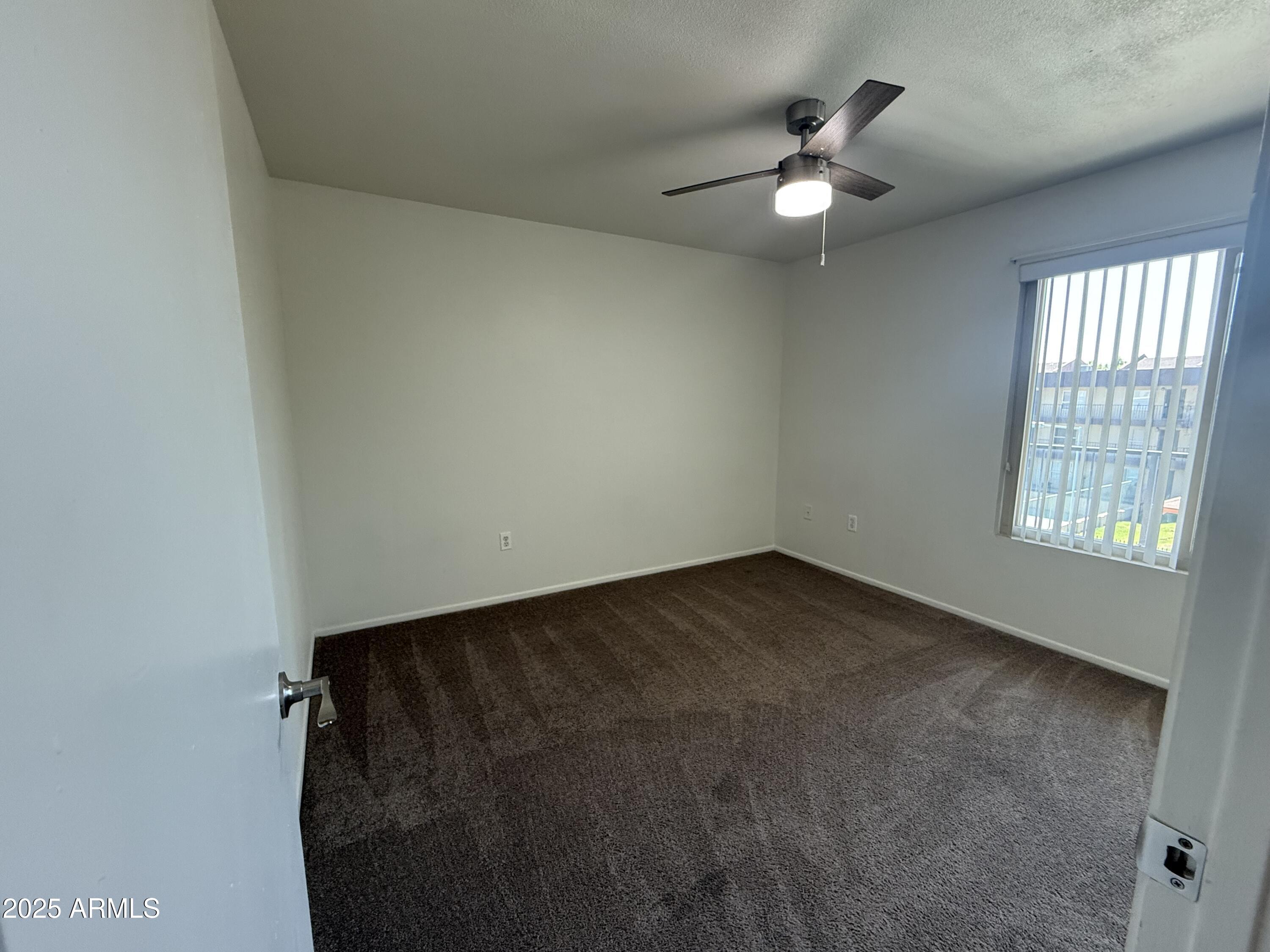 461 West Holmes Avenue, Unit 342 Mesa, AZ 85210 - Photo 17 of 21 an empty room with a window and a ceiling fan