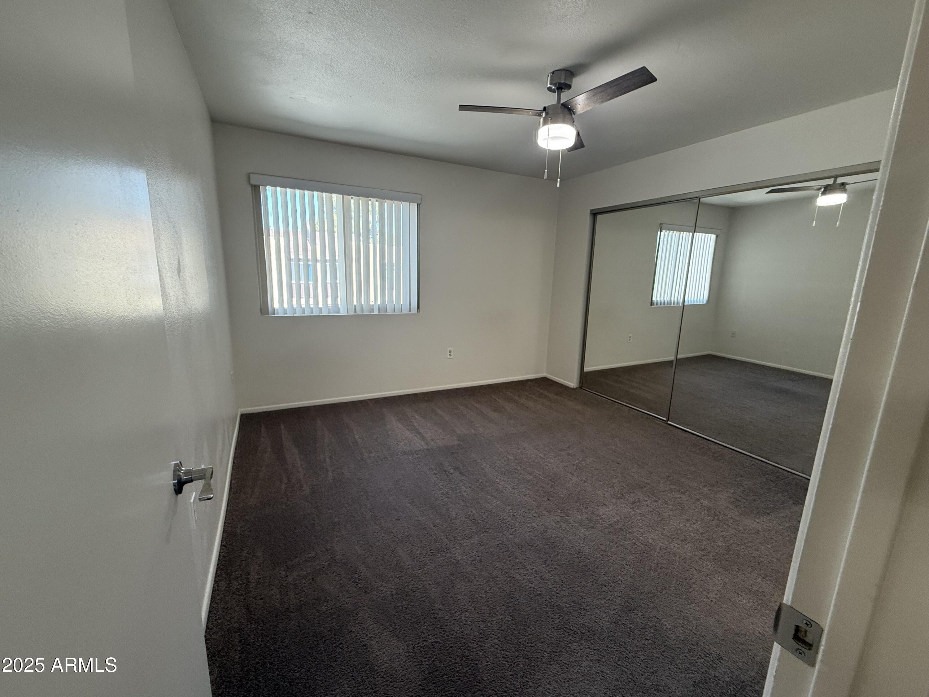 461 West Holmes Avenue, Unit 342 Mesa, AZ 85210 - Photo 18 of 21 an empty room with windows and fan