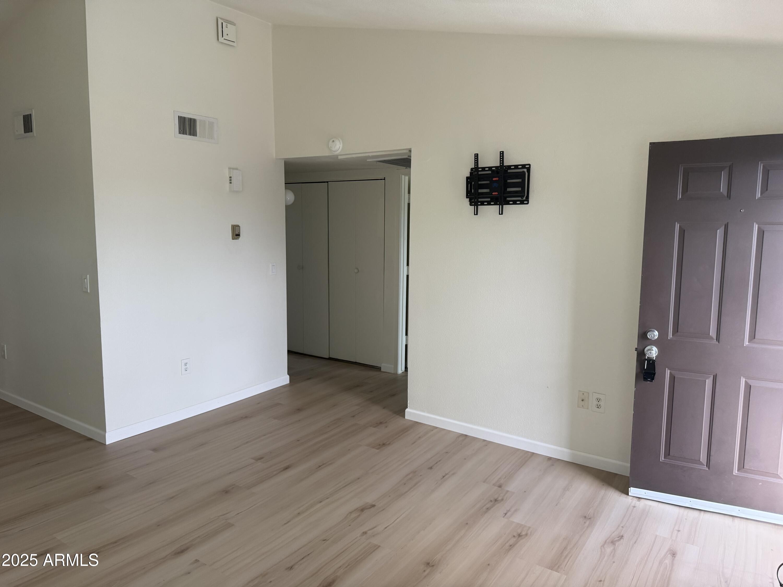 461 West Holmes Avenue, Unit 342 Mesa, AZ 85210 - Photo 5 of 21 an empty room with wooden floor and windows