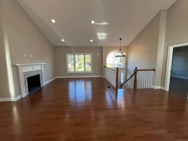 a view of a livingroom with fireplace wooden floor and windows