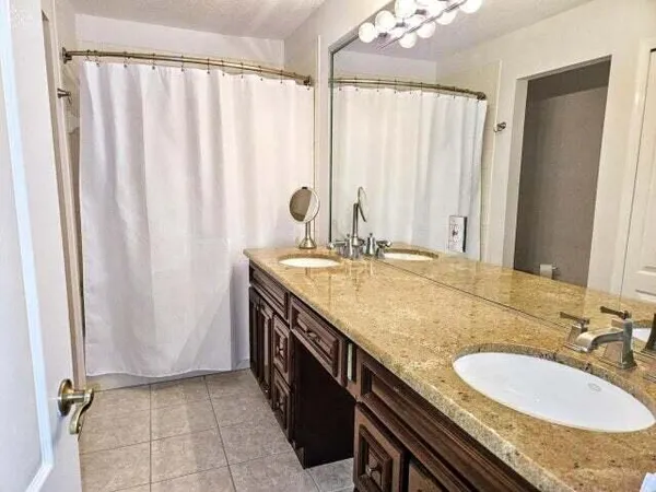 a bathroom with a granite countertop sink and a mirror