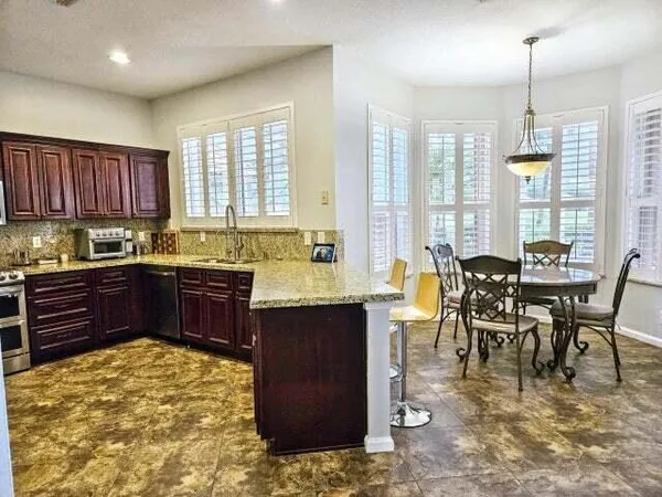 a kitchen with a stove a sink a center island and a wooden cabinets