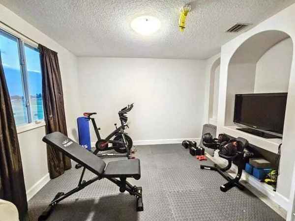 a room with gym equipment and a flat screen tv