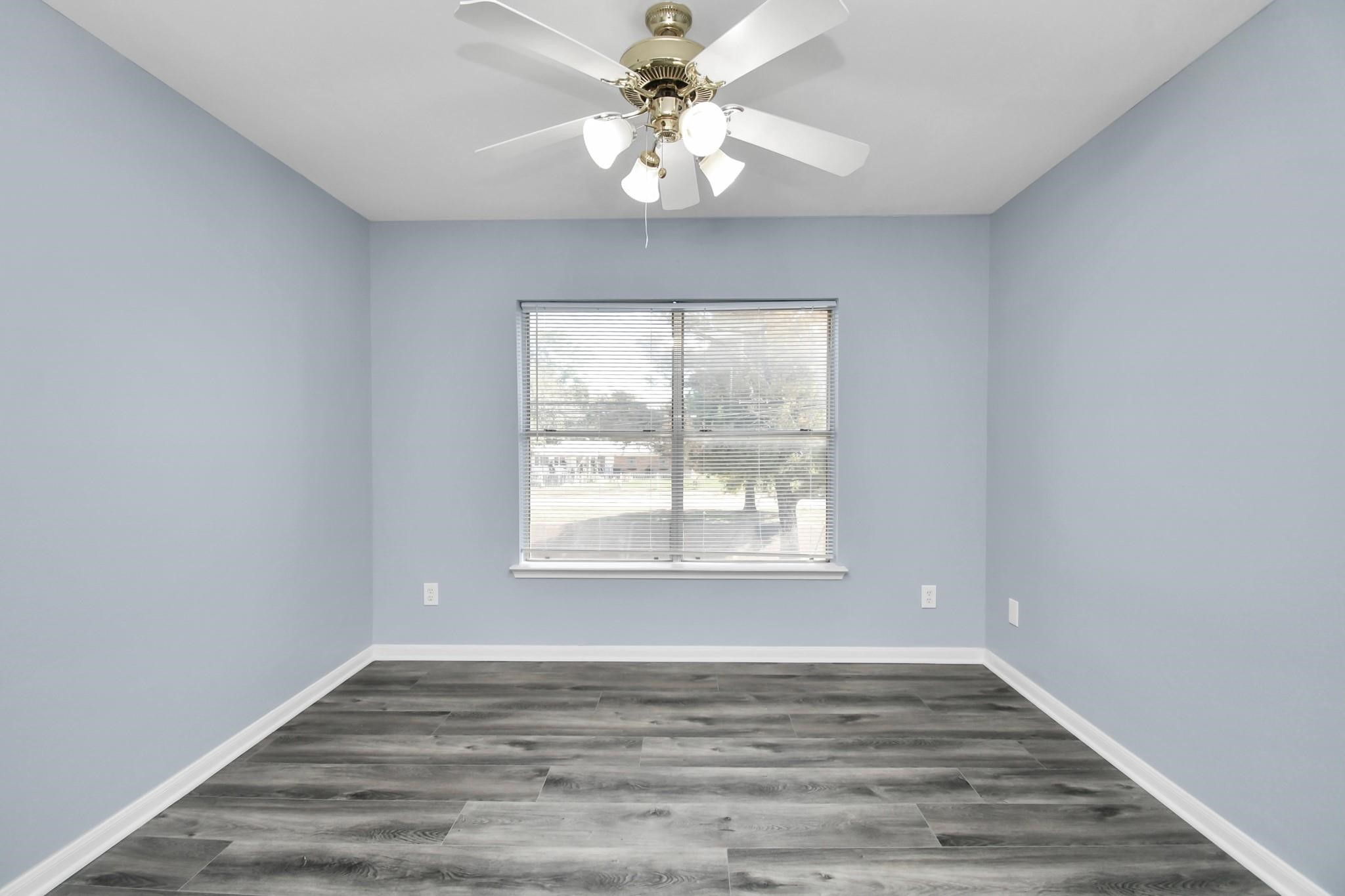 10403 Shadow Oaks Drive, Unit 3A Houston, TX 77043 - Photo 16 of 25 an empty room with wooden floor chandelier fan and windows