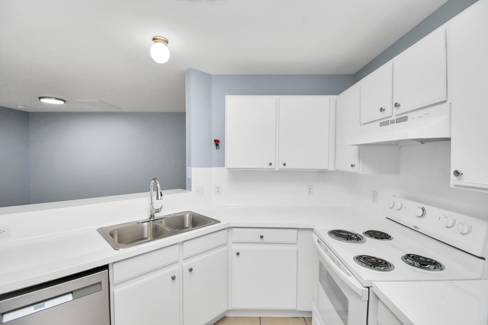 10403 Shadow Oaks Drive, Unit 3A Houston, TX 77043 - Photo 5 of 25 a kitchen with a sink a stove and cabinets