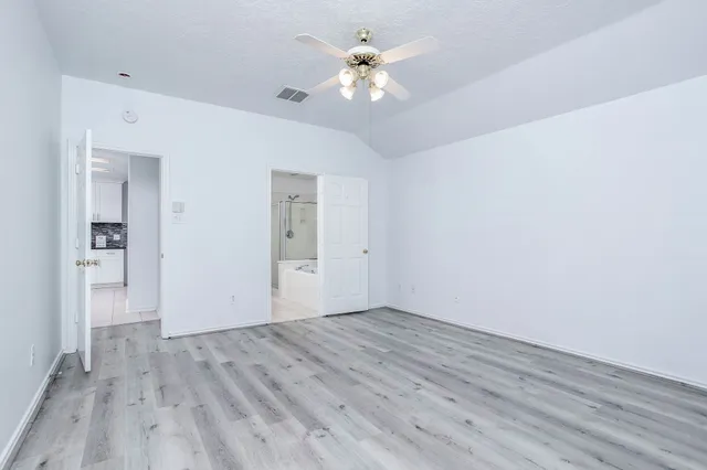 a view of a room with wooden floor and a ceiling fan