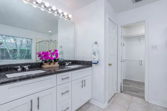 a kitchen with white cabinets and window