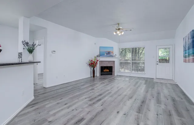 a view of empty room with wooden floor and fireplace