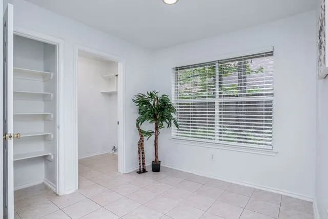 a view of an empty room with a window and a potted plant