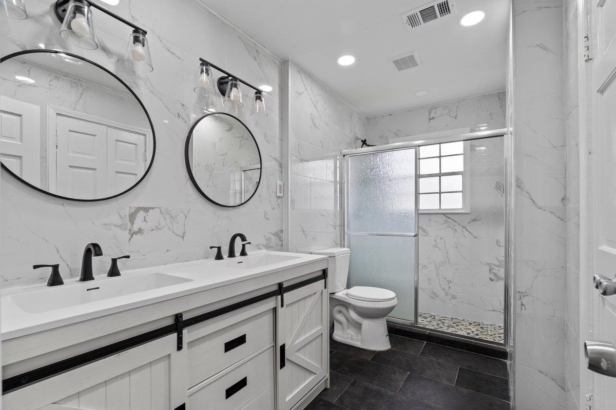 5841 Foxdale Road Memphis, TN 38115 - Photo 15 of 21 a bathroom with a double vanity sink mirror and toilet