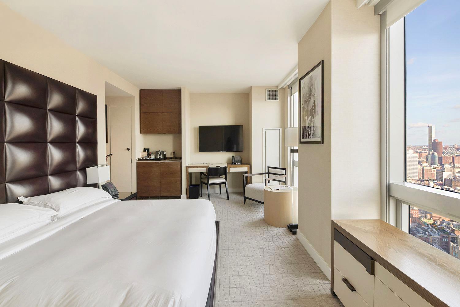 246 Spring Street, Unit 3504 Manhattan, NY 10013 - Photo 3 of 11 a large bedroom with a large bed tv and furniture