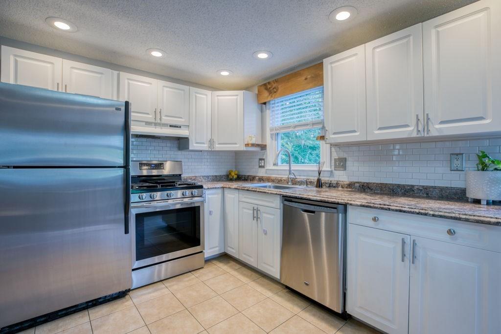 136 Webber Street Springfield, MA 01108 - Photo 4 of 29 a kitchen with granite countertop white cabinets and stainless steel appliances