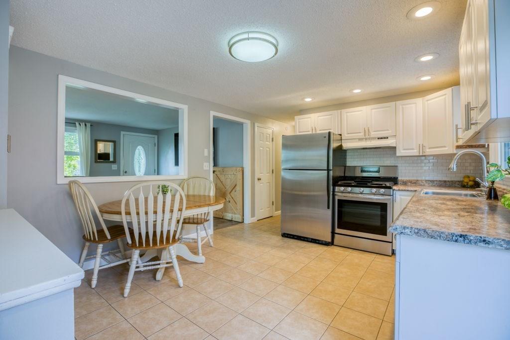 136 Webber Street Springfield, MA 01108 - Photo 7 of 29 a kitchen with stainless steel appliances granite countertop a stove a sink a refrigerator with a dining table and chairs