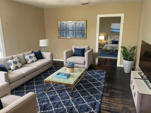 a living room with furniture a rug and a table
