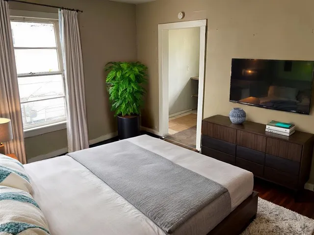a bedroom with a bed and a flat screen tv
