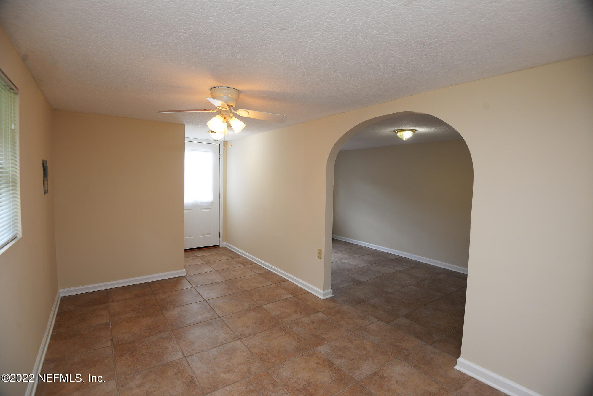 3973 Gadsden Road Jacksonville, FL 32207 - Photo 38 of 45 an empty room with a chandelier fan and windows