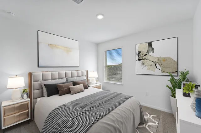 a bed room with a bed and a painting on the wall