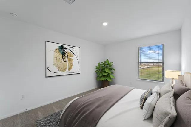 a bedroom with a bed and a painting on the wall