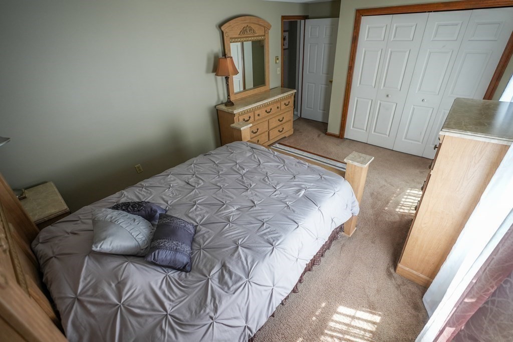 283 Fuller Road, Unit E Chicopee, MA 01020 - Photo 16 of 21 a bedroom with a bed and wooden floor