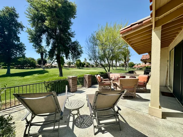 a view of a patio with couches table and chairs with a yard