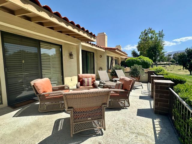 a view of a patio with couches table and chairs and potted plants