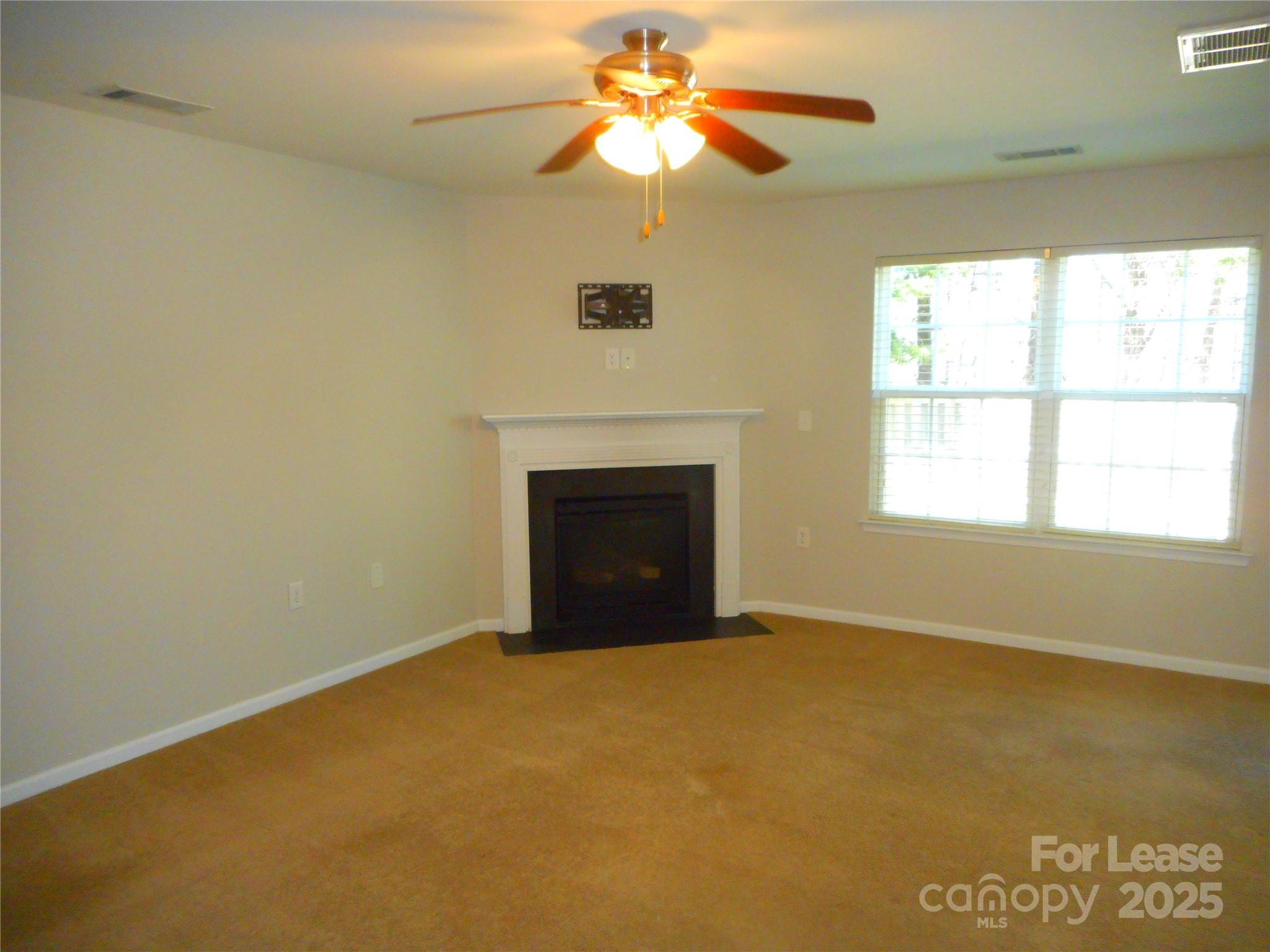 1004 Marcus Street Indian Land, SC 29707 - Photo 3 of 26 a view of an empty room with chandelier fan and a fireplace