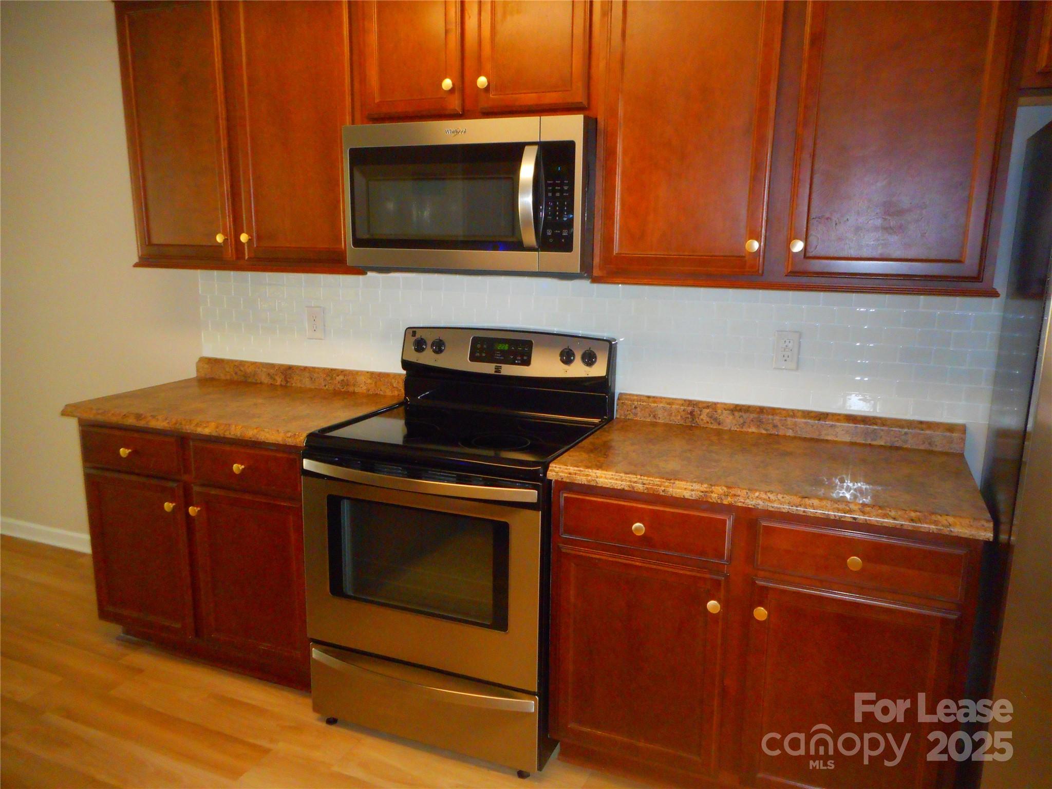1004 Marcus Street Indian Land, SC 29707 - Photo 4 of 26 a kitchen with granite countertop wood cabinets stainless steel appliances and a sink