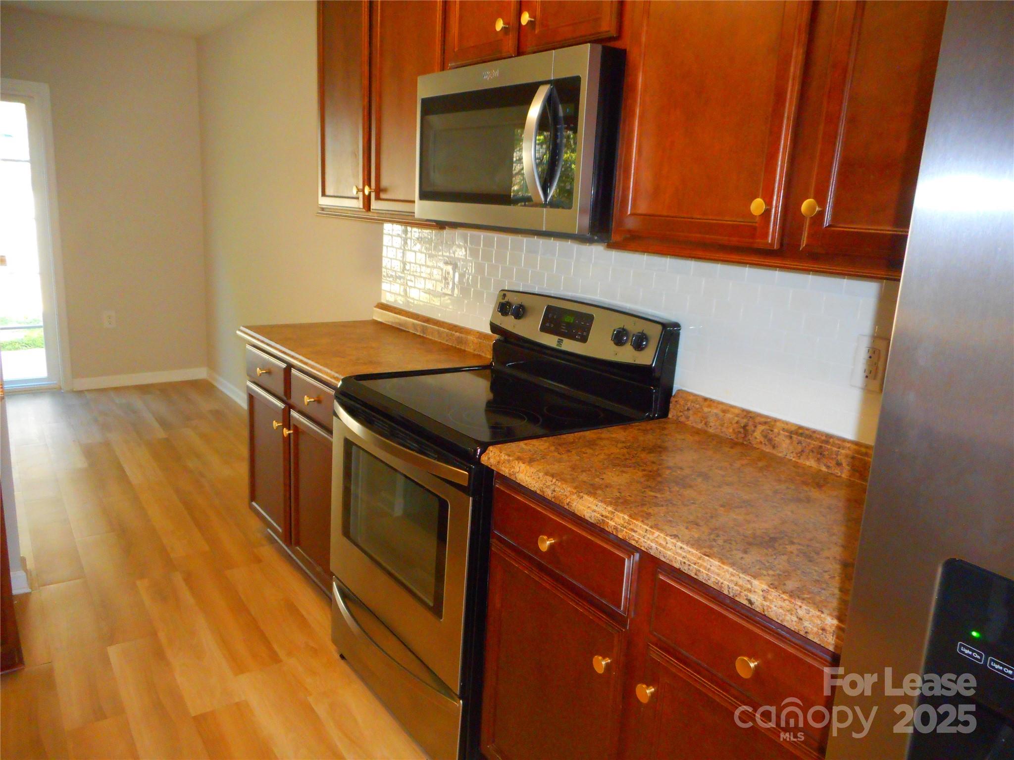 1004 Marcus Street Indian Land, SC 29707 - Photo 5 of 26 a kitchen with wooden cabinets and a stove top oven