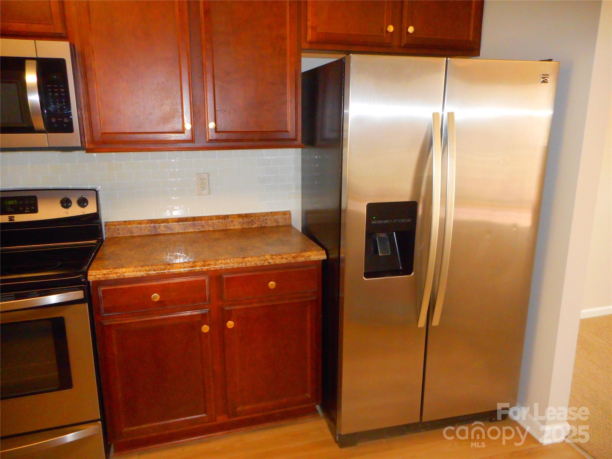 1004 Marcus Street Indian Land, SC 29707 - Photo 7 of 26 a room with stainless steel appliances granite countertop a refrigerator and a stove