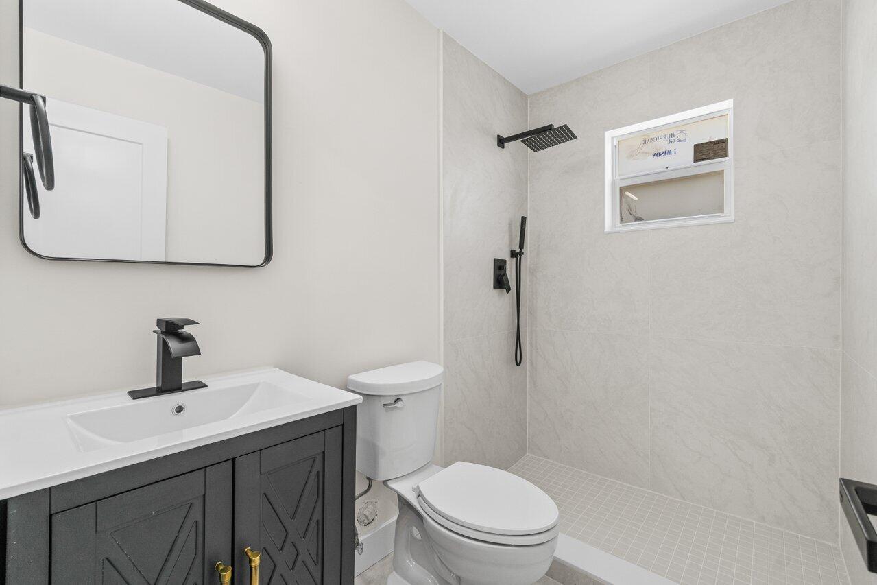 4498 Northwest 2nd Avenue Boca Raton, FL 33431 - Photo 33 of 43 a bathroom with a toilet sink and mirror