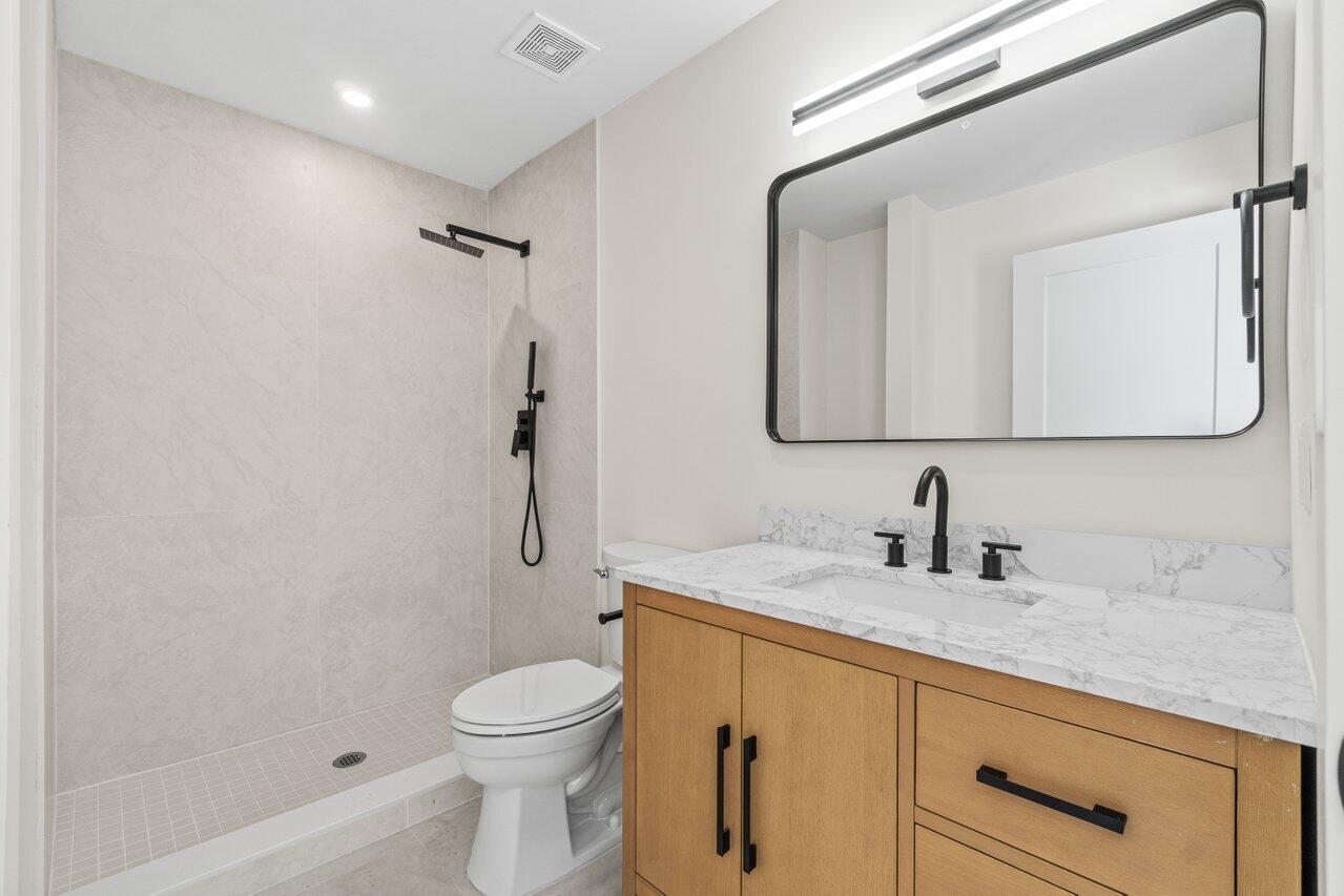 4498 Northwest 2nd Avenue Boca Raton, FL 33431 - Photo 34 of 43 a bathroom with a granite countertop sink toilet and shower