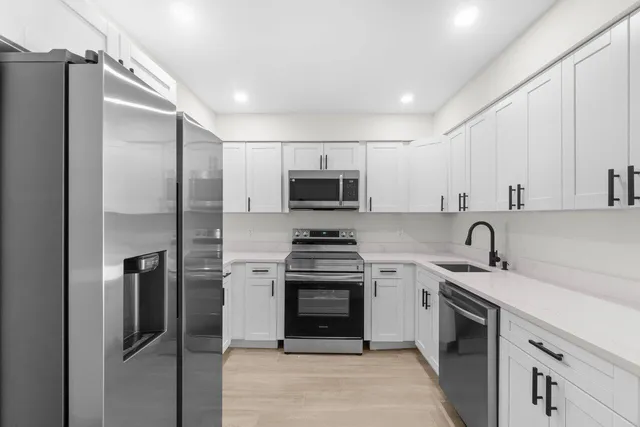 a kitchen with stainless steel appliances granite countertop a refrigerator stove and sink