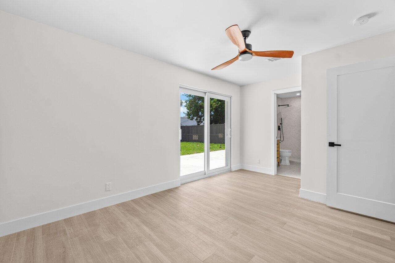4498 Northwest 2nd Avenue Boca Raton, FL 33431 - Photo 10 of 43 a view of an empty room with wooden floor and a ceiling fan