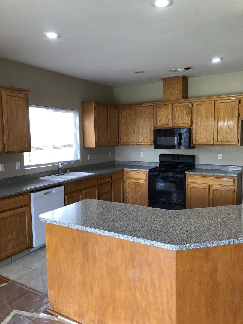 6565 Nicholas Drive Winton, CA 95388 - Photo 6 of 17 a kitchen with stainless steel appliances granite countertop a sink a stove and a refrigerator